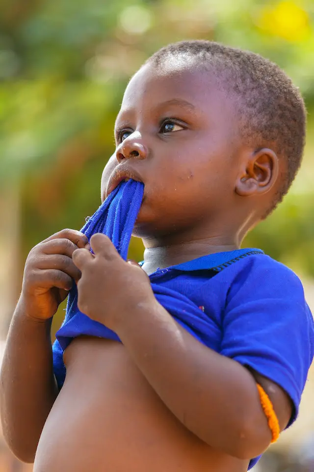 boy chewing on a shirt